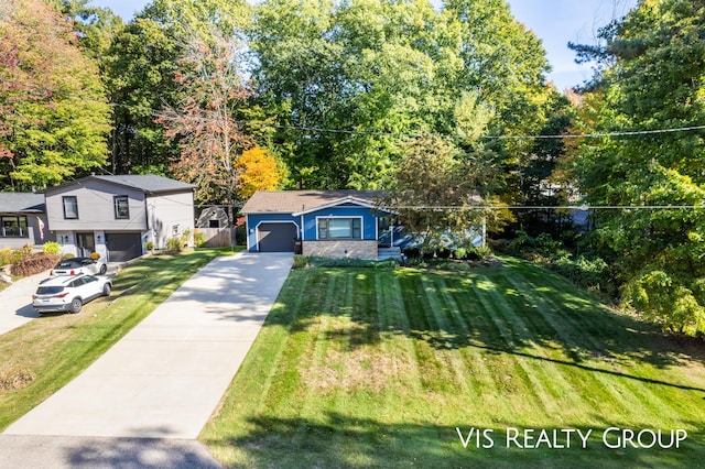 view of front of home with an attached garage, concrete driveway, and a front yard