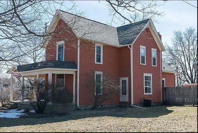 view of side of home featuring a porch, cooling unit, fence, and a chimney