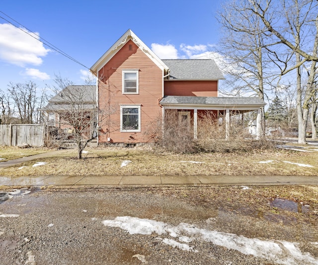 view of property exterior featuring fence and a shingled roof