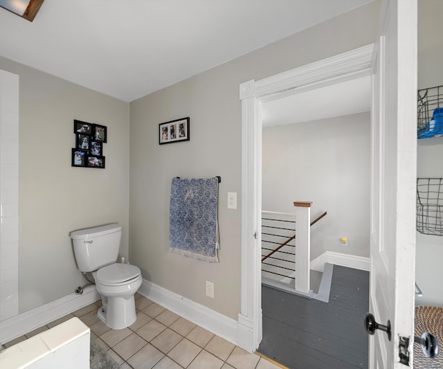 bathroom featuring tile patterned floors, baseboards, and toilet