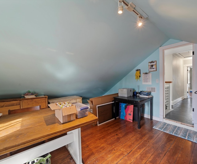 office featuring baseboards, attic access, vaulted ceiling, rail lighting, and hardwood / wood-style flooring