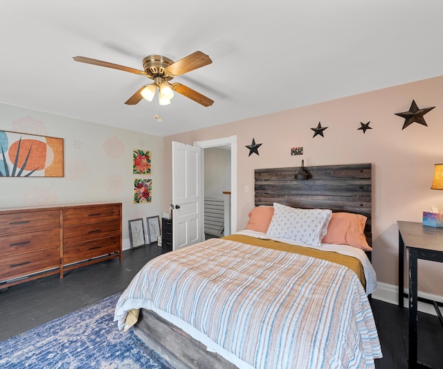 bedroom featuring baseboards, wood finished floors, and a ceiling fan