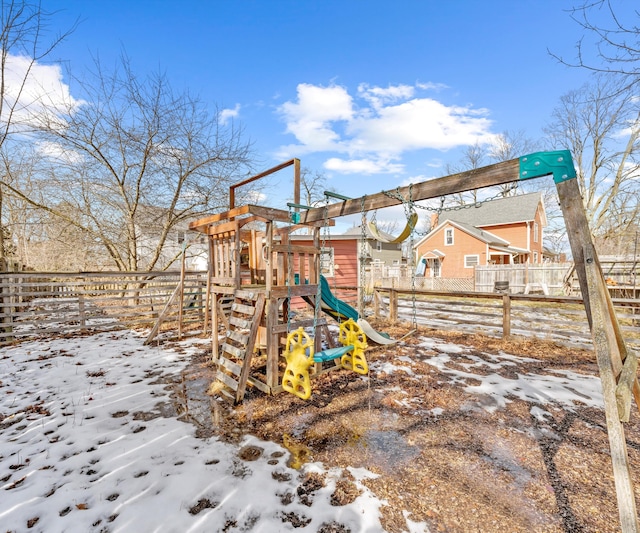 snow covered playground with a playground and fence