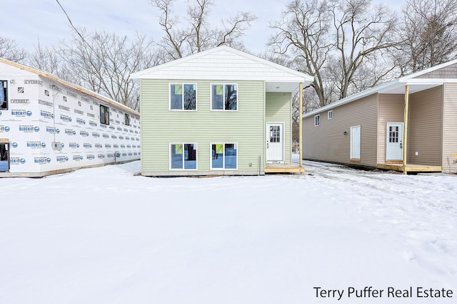 view of snow covered back of property