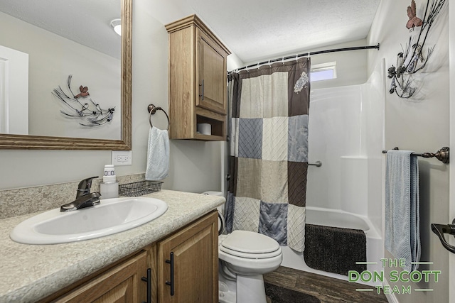 bathroom featuring vanity, toilet, shower / tub combo with curtain, and a textured ceiling