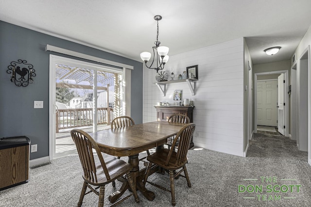 carpeted dining room with visible vents, baseboards, and an inviting chandelier