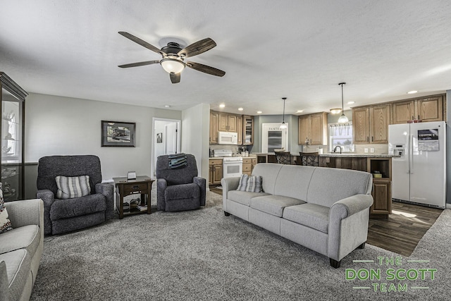 living area with dark wood finished floors, recessed lighting, a ceiling fan, and a textured ceiling