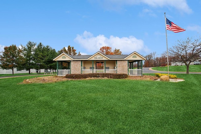 view of front of property featuring a porch, brick siding, and a front yard