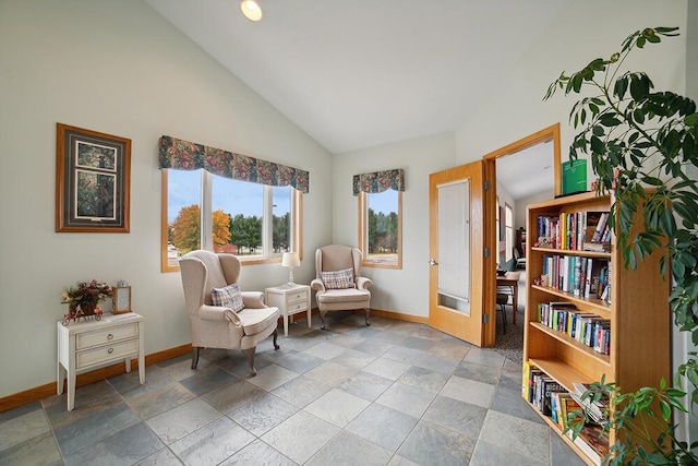 living area with baseboards and vaulted ceiling