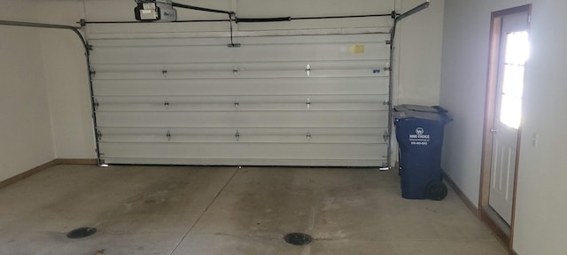 garage with a garage door opener and baseboards