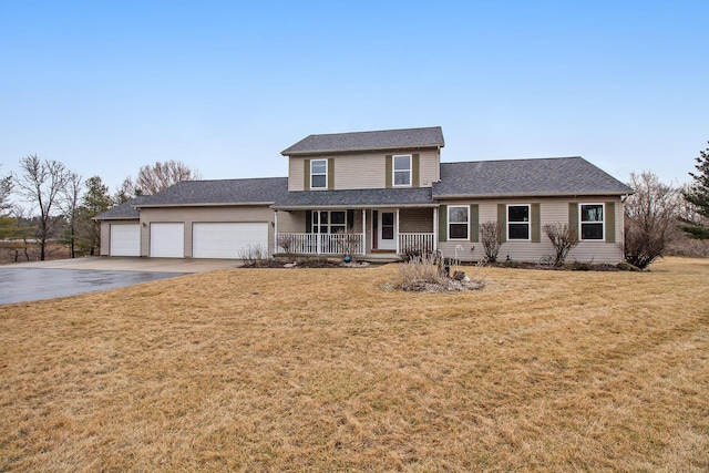 traditional home featuring a garage, a porch, concrete driveway, and a front yard