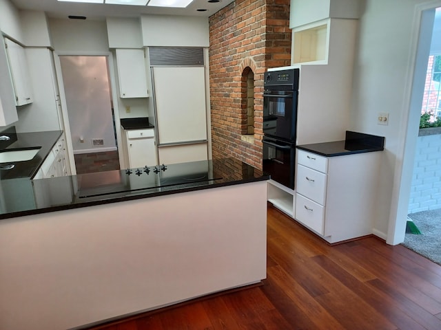 kitchen with black appliances, a sink, dark countertops, white cabinetry, and dark wood-style flooring