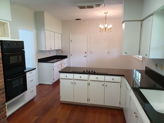 kitchen with dark wood finished floors, a peninsula, black appliances, white cabinetry, and dark countertops