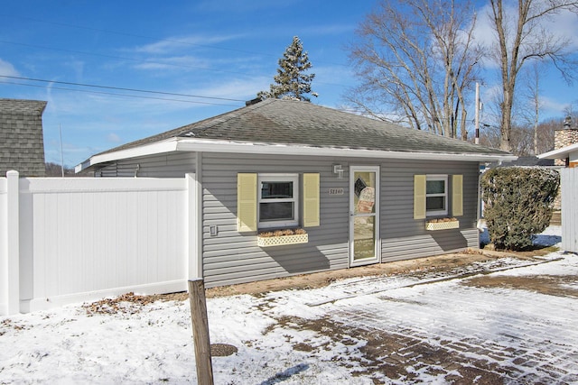 view of front of property featuring a shingled roof and fence