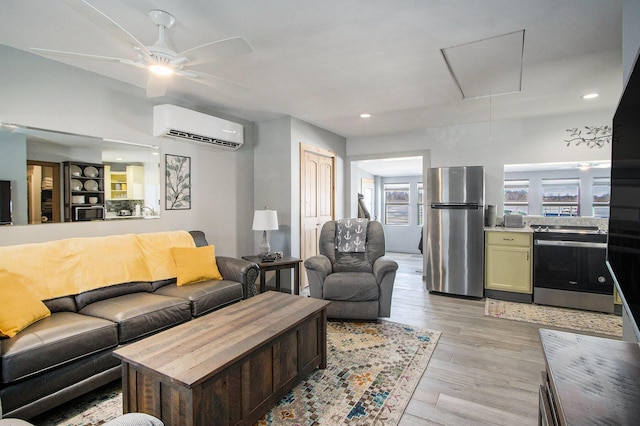 living area featuring a ceiling fan, attic access, light wood-style flooring, recessed lighting, and an AC wall unit