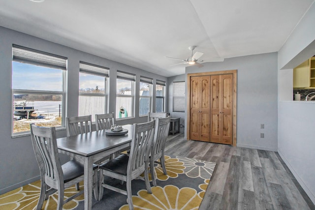 dining room featuring a ceiling fan, baseboards, and wood finished floors