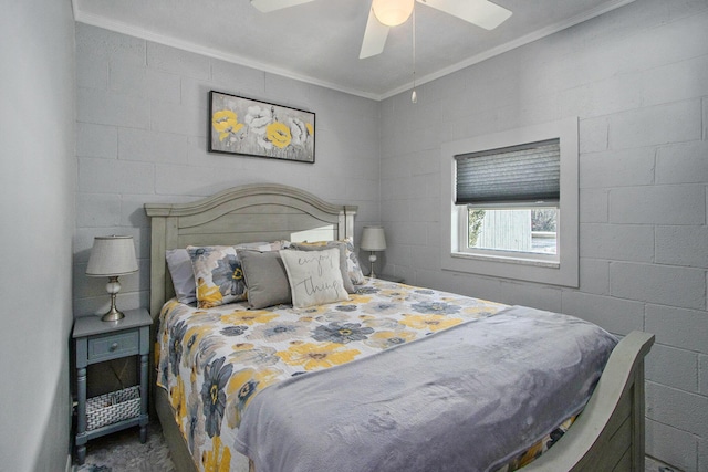 bedroom featuring concrete block wall, ceiling fan, and ornamental molding