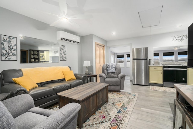living room with light wood-style floors, attic access, recessed lighting, an AC wall unit, and a ceiling fan
