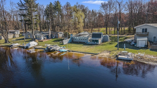 view of dock with a yard and a water view
