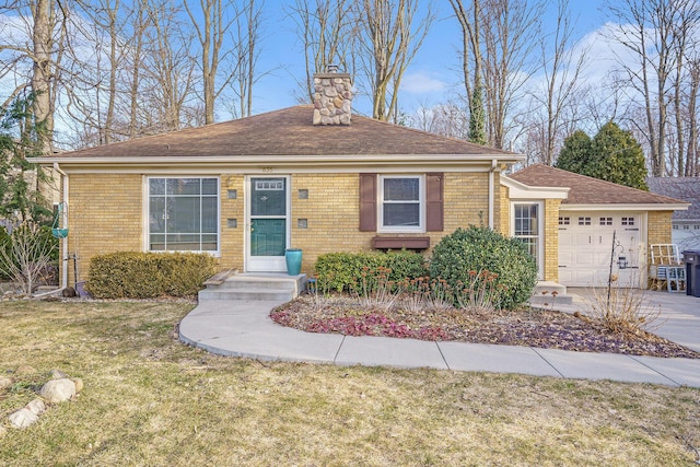 view of front of home with brick siding, a chimney, a garage, and a front yard