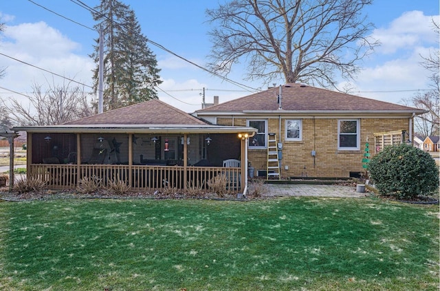 back of property with a yard, a patio, brick siding, and roof with shingles