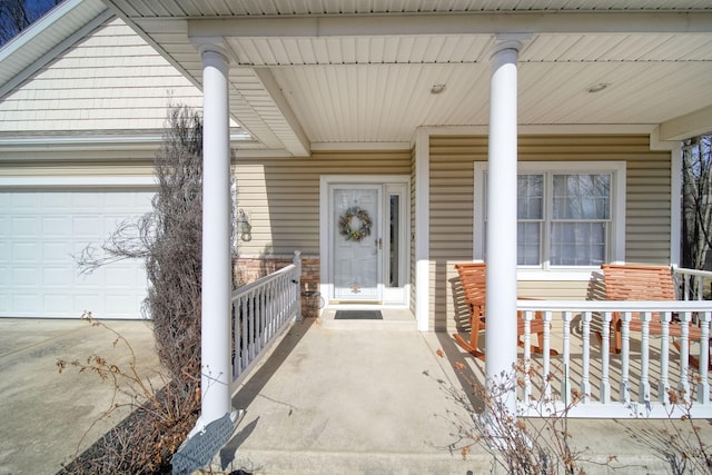 doorway to property with a garage and a porch