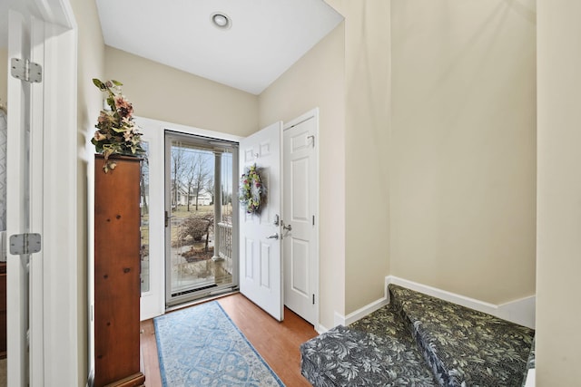 foyer featuring baseboards and wood finished floors