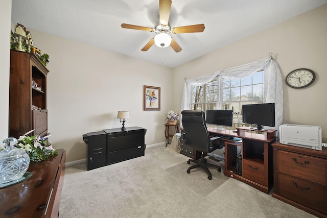 carpeted office featuring a ceiling fan and baseboards