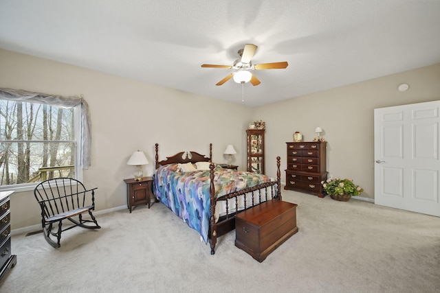 carpeted bedroom with ceiling fan and baseboards