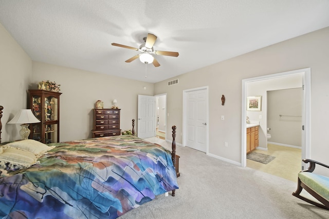 bedroom featuring visible vents, baseboards, light carpet, ensuite bath, and a textured ceiling