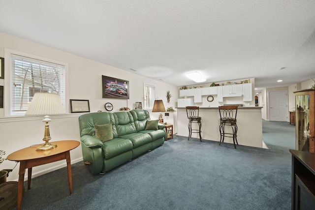 living room with a textured ceiling and dark carpet