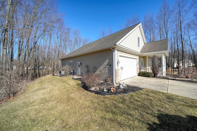 view of side of home with roof with shingles, an attached garage, concrete driveway, stone siding, and a lawn