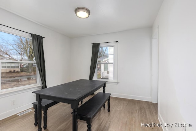 dining room featuring visible vents, baseboards, and wood finished floors