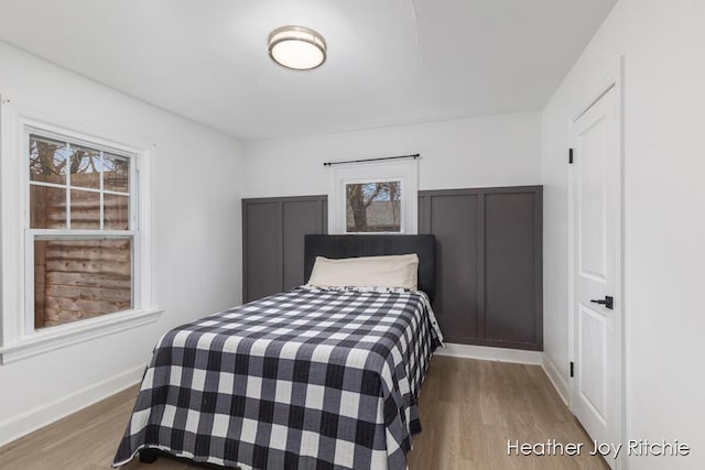 bedroom with baseboards and wood finished floors