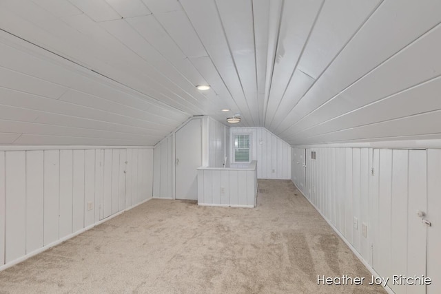 bonus room featuring lofted ceiling and light carpet