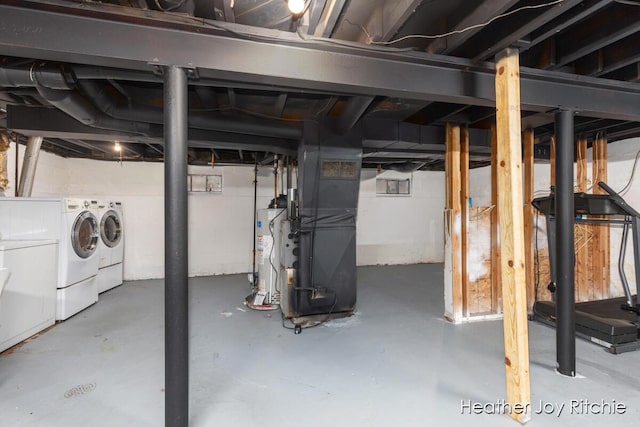 unfinished basement with gas water heater, heating unit, and washer and clothes dryer