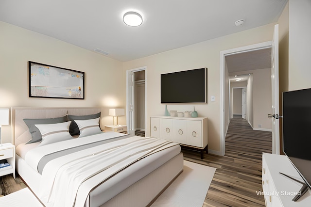 bedroom with visible vents, baseboards, and wood finished floors