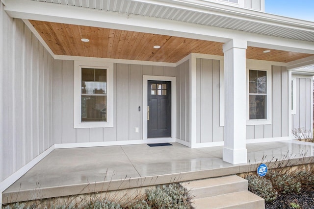 view of exterior entry featuring board and batten siding and covered porch