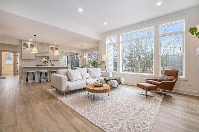 living area with light wood-style flooring, recessed lighting, and baseboards