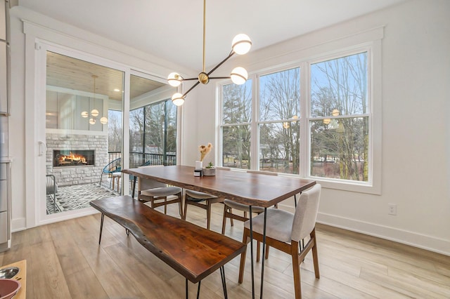 dining room featuring light wood finished floors, a fireplace, and a wealth of natural light