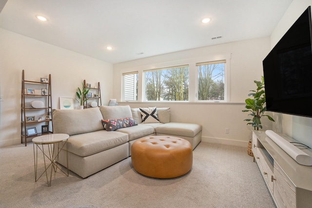 living area with visible vents, recessed lighting, light colored carpet, and baseboards