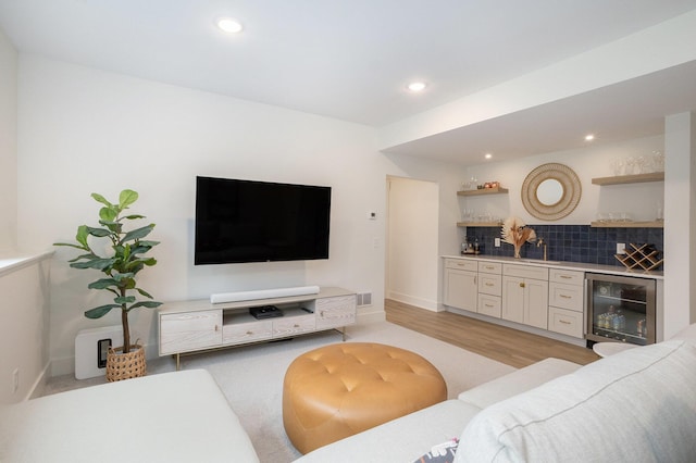 living area with beverage cooler, visible vents, recessed lighting, a bar, and light wood-style floors