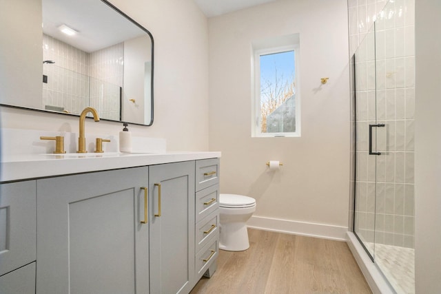 full bathroom featuring vanity, wood finished floors, baseboards, a shower stall, and toilet