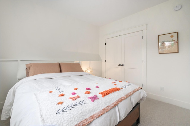 bedroom with carpet flooring, baseboards, and a closet