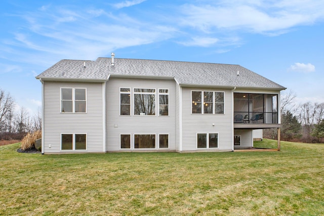 back of property with a yard, a shingled roof, and a sunroom