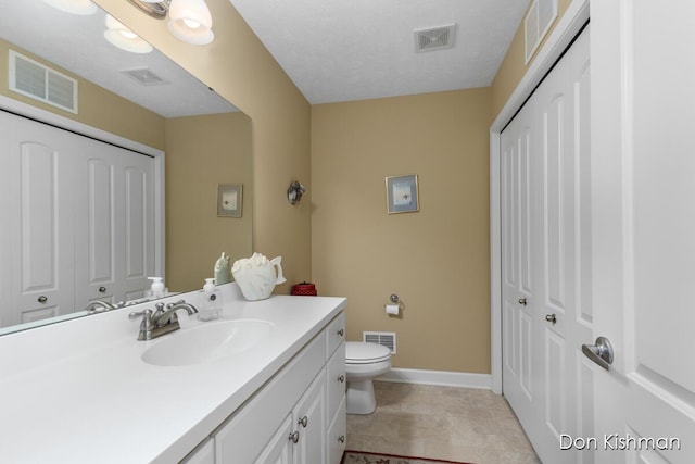 bathroom featuring visible vents, toilet, and vanity