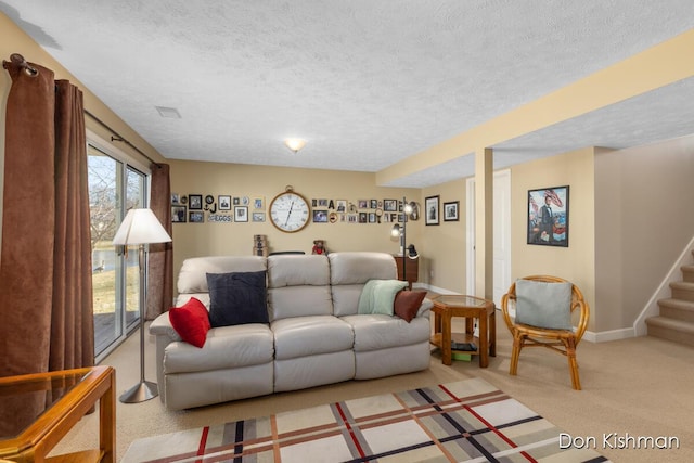 living area with stairs, light colored carpet, and a textured ceiling