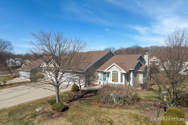 view of front of property featuring driveway and a chimney