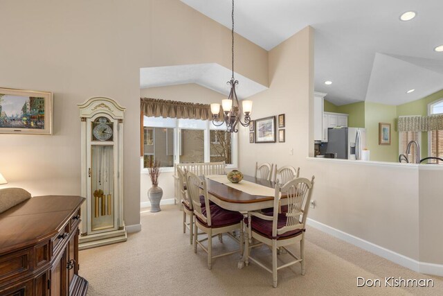 dining area featuring light carpet, plenty of natural light, and vaulted ceiling