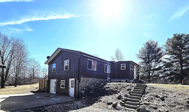 view of side of property featuring a patio area and stone siding